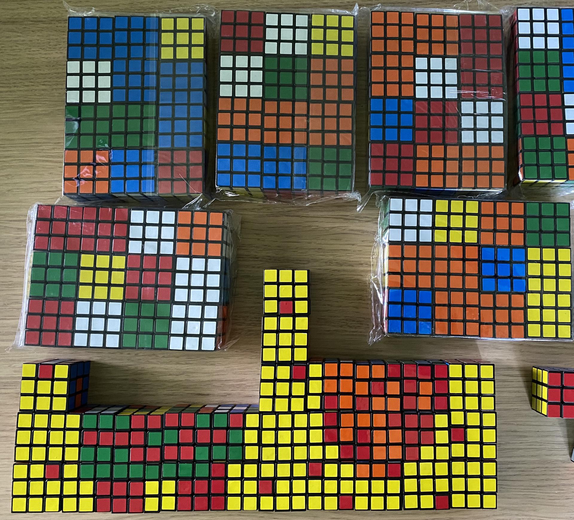 A collection of many Rubik's Cubes on a table